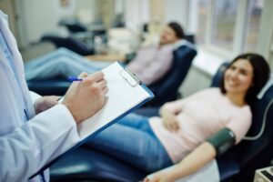 Phlebotomist Taking Notes Near Patient Phlebotomist Taking Notes Near Patient