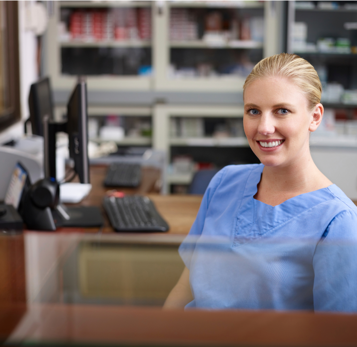 Medical biller sitting in an office desk smiling