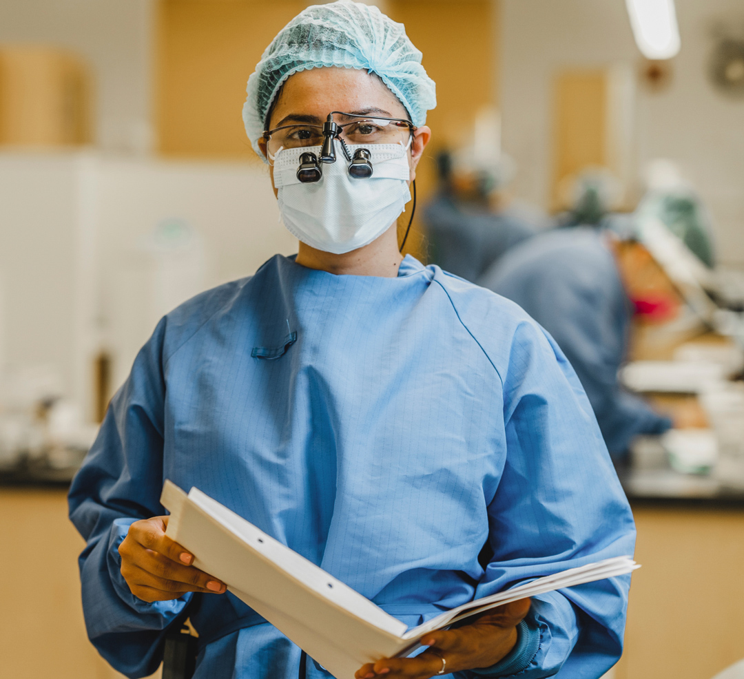 Dental hygienist with dental loupes holding a folder