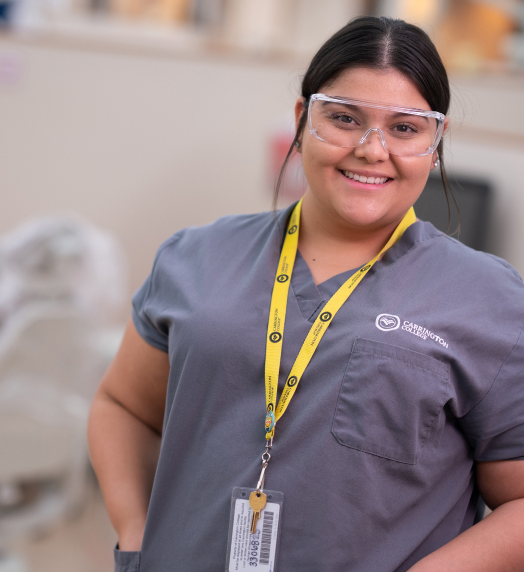 Carrington College Dental Hygiene student with goggles smiling