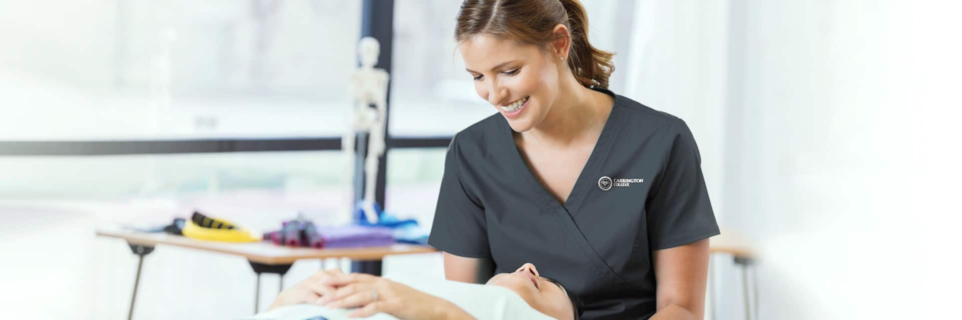 Young woman in dark scrubs treating female massage patient.