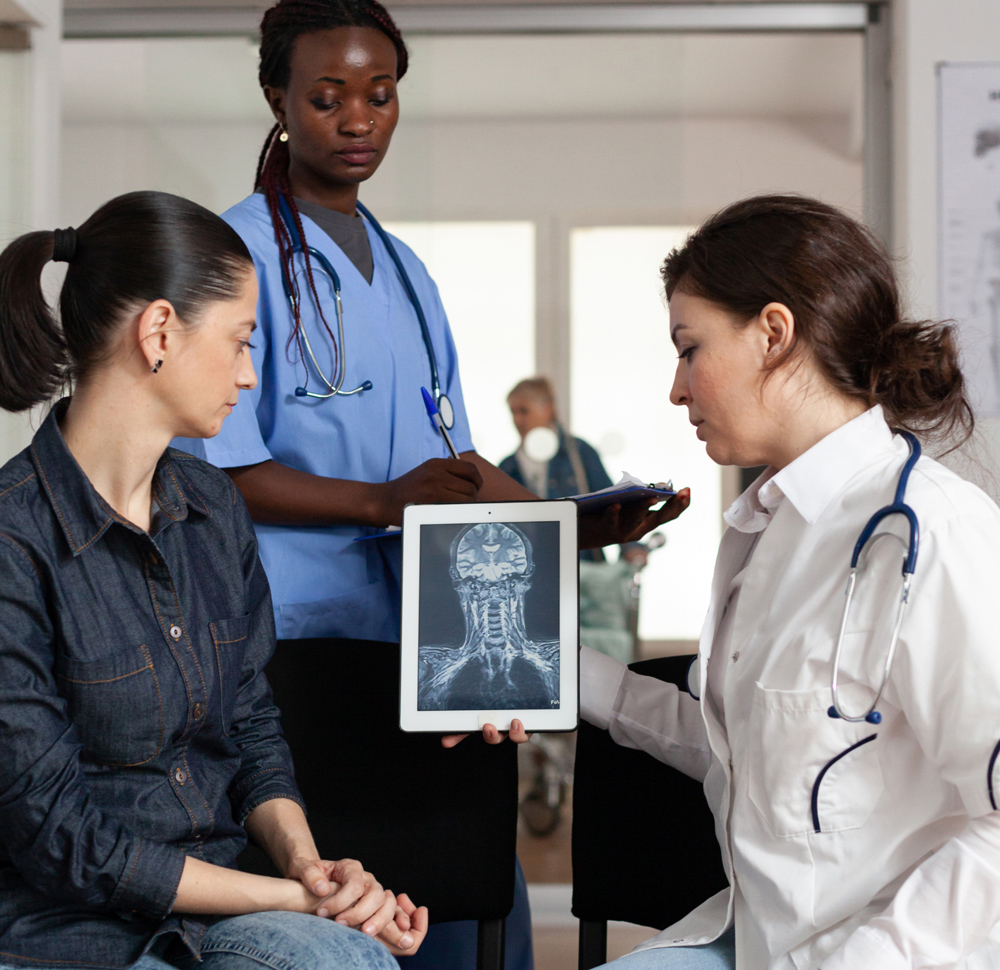 Medical radiologic technologists showing patient an x-ray scan on a tablet