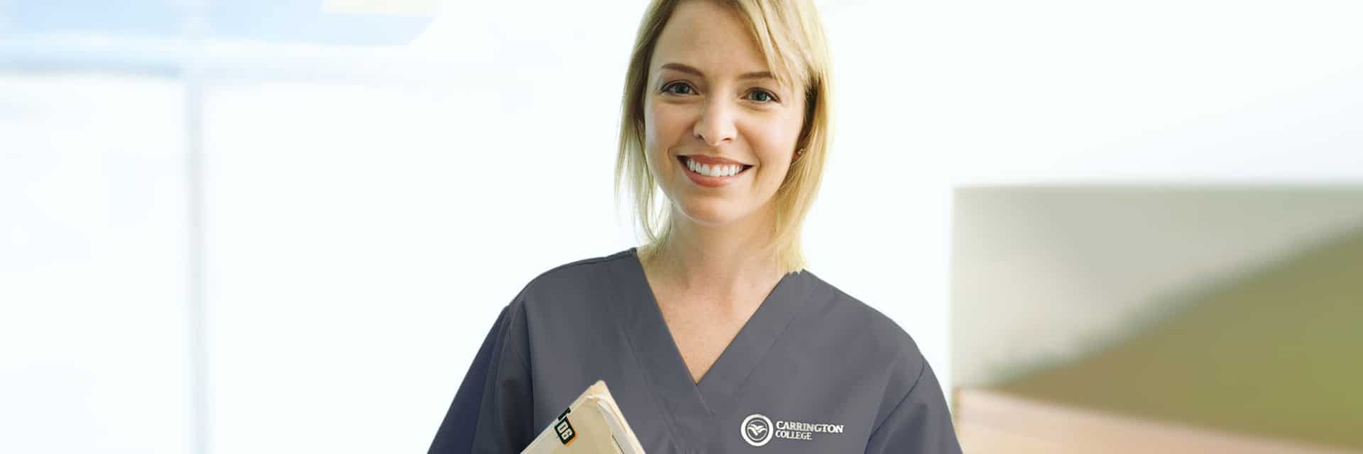 Young women in scrubs with records folder.