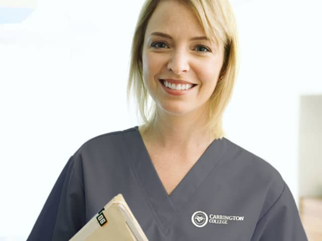 Young women in scrubs with records folder.