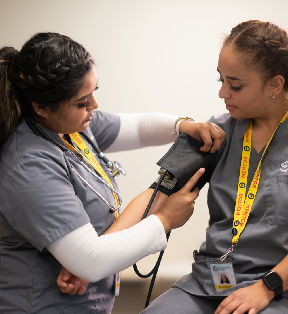 Carrington College nursing students practicing blood pressure tests