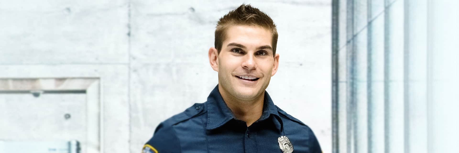 Young man in dark blue security uniform.