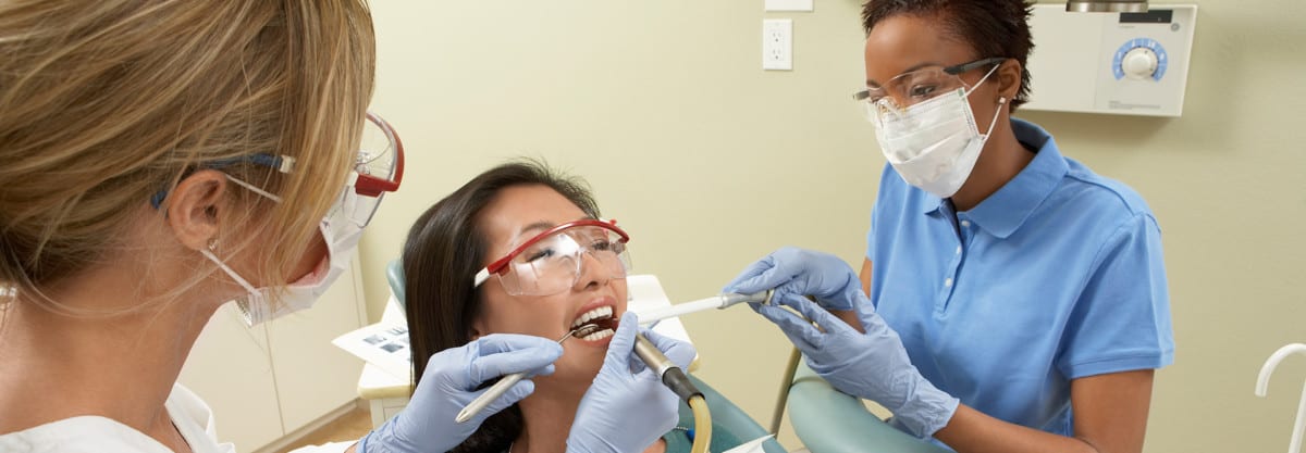 Dental Assistant performing a teeth cleaning