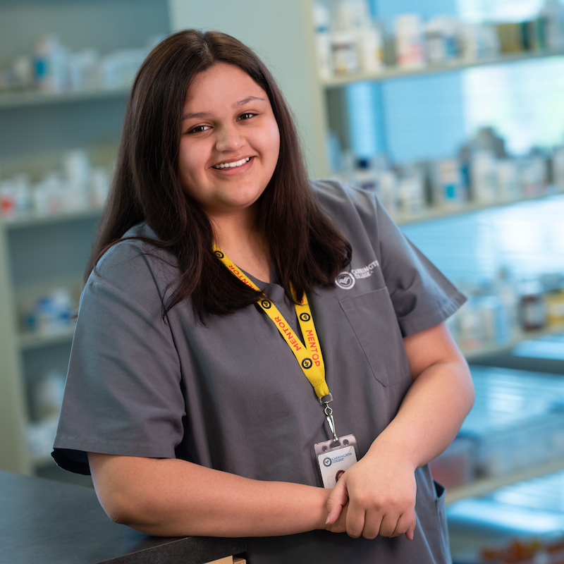 Carrington College pharmacy technology student in pharmacy smiling