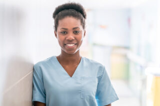 Portrait of beautiful african american doctor wearing scrubs looking at camera smiling